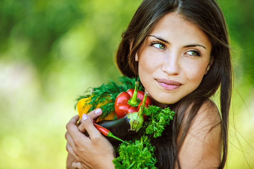 woman with bare shoulders holding vegetable