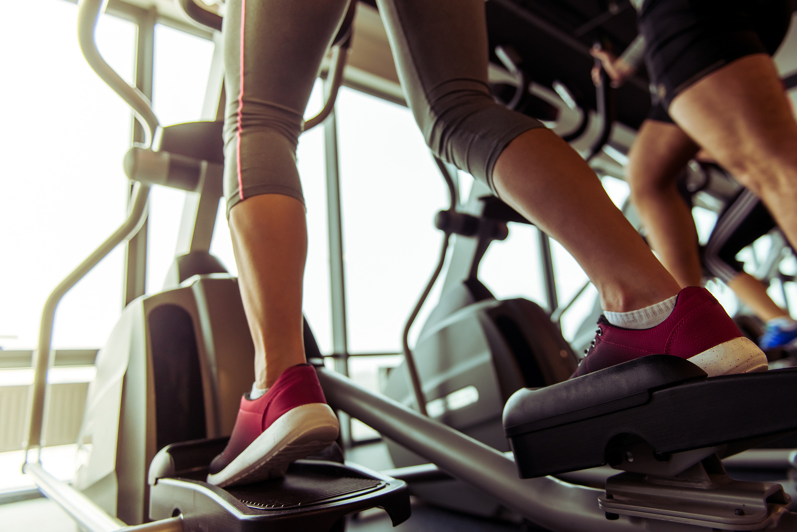 Woman working out on elliptical for fat loss.